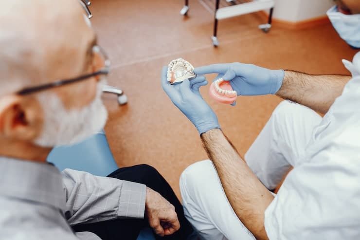 Dentist adjusting dentures for patient