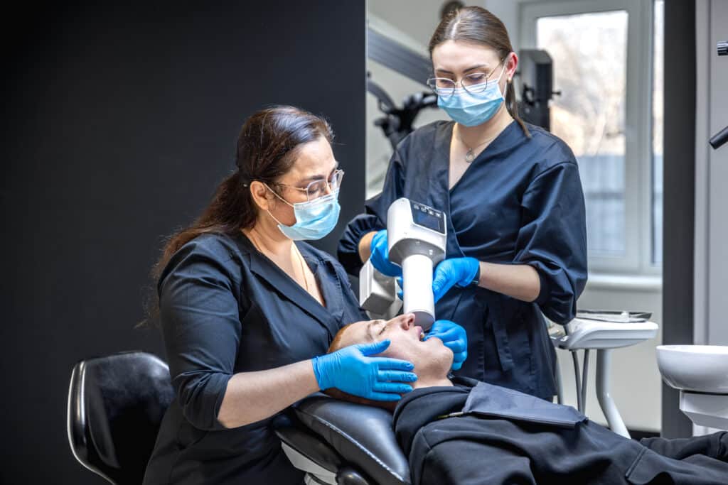 Dental team treating patient with modern equipment