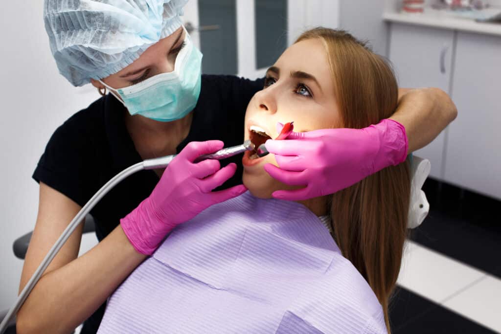 Dentist treating patient gums during periodontal procedure