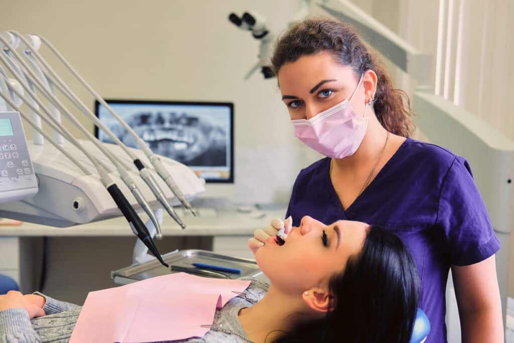 Dentist examining teeth during periodontal maintenance